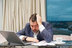 累了男人。工作首页办公室疲惫强调过度劳累男人。不成功的金融投资