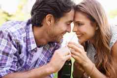 自然快乐夫妇分享喝爱夏天野餐日期户外花园幸福微笑年轻的男人。女人喝瓶尾巴放松草场