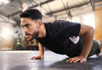 健身培训推男人。健身房培训肌肉锻炼耐力的决心强大的权力健美运动员地板上锻炼体育健康运动员