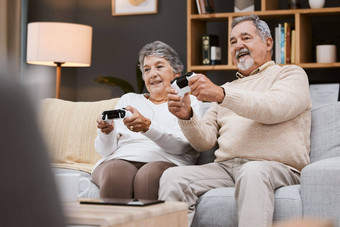 视频游戏沙发高级夫妇游戏在线首页快乐假期退休生活方式技术兴奋上了年纪的玩家人沙发上生活房间游戏
