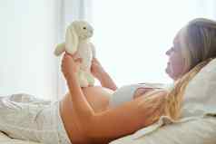 大工作兔子怀孕了女人持有塞玩具坐着床上