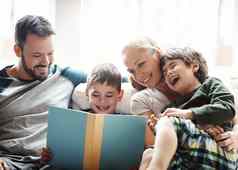 家庭书夫妇阅读孩子们沙发笑快乐讲故事时间首页爱学习孩子发展男人。女人孩子们阅读书沙发上微笑