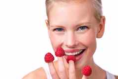 手指食物有趣的美丽的年轻的女人开玩笑地吃树莓指尖