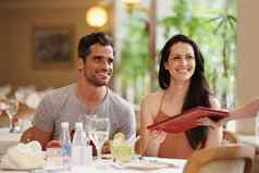 享受餐厅优雅的气氛快乐年轻的夫妇日期花俏的餐厅