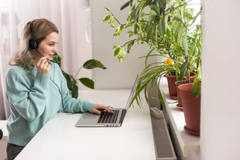 积极的年轻的女人移动PC首页视频会议舒适的首页室内室内植物远程工作业务自由在线购物电子学习概念