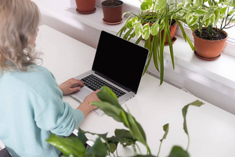 年轻的微笑快乐满意员工业务女人休闲蓝色的衬衫持有笔坐工作工作场所白色桌子上移动PC电脑光现代办公室在室内成就职业生涯概念