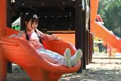 快乐孩子女孩幻灯片有趣的户外操场上童年设备娱乐公园