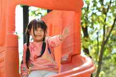 微笑亚洲女孩有趣的户外操场上童年设备娱乐公园孩子们