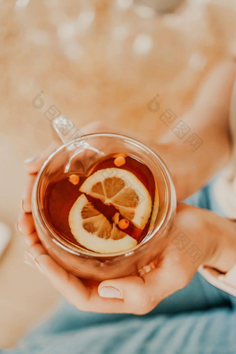 杯茶柠檬女手前视图女手持有透明的杯茶柠檬