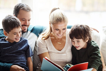 妈妈爸爸孩子们阅读书沙发<strong>讲故事</strong>时间微笑快乐家庭首页爱学习夫妇孩子们书幻想故事沙发上增长孩子发展