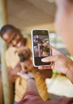 电话图片狗女人手显示男人。宠物户外幸福黑色的男人。小狗黑色的女人夫妇成键拥抱移动技术相机微笑