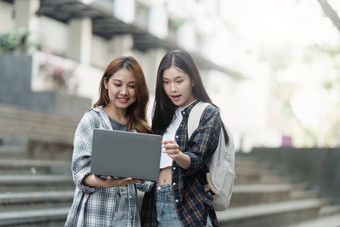 美丽的年轻的亚洲女人大学学生朋友在户外大学学生工作大学校园