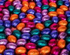 桩闪亮的包装巧克力复活节鸡蛋颜色红色的蓝色的金绿色紫色的节日复活节概念前视图粉红色的背景快乐复活节特写镜头糖果糖果概念