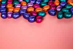 桩闪亮的包装巧克力复活节鸡蛋颜色红色的蓝色的金绿色紫色的节日复活节概念前视图粉红色的背景快乐复活节特写镜头糖果糖果概念