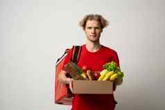 交付男人。红色的统一的交付食物食品杂货蔬菜饮料纸盒子客户端首页在线杂货店购物服务概念