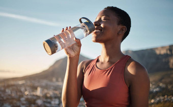 黑色的女人跑步者喝水户外锻炼培训锻炼马拉松运行复苏非洲女人健康的运动员水合物瓶健身健康有氧运动运行