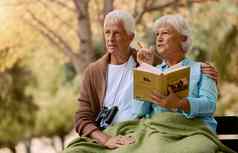 观鸟书双筒望远镜高级夫妇坐着公园板凳上自然森林爱退休成熟的男人。女人花园放松夏天视图