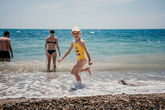 可爱的女孩运行海滨清晰的蓝色的海喜乐射线夏天<strong>太阳</strong>美丽的女孩黄色的泳衣运行有趣的热带海滩