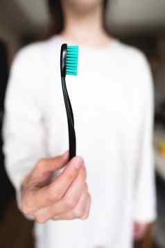 女人持有牙刷前景焦点模糊背景口服卫生