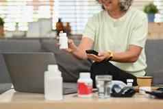 成熟的女人持有药片瓶讨论处方药物医生视频调用远程医疗咨询概念