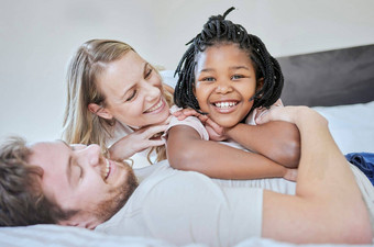 爱采用家庭肖像放松微笑床上首页快乐支持护理妈妈。父亲黑色的女孩幸福自由卧室放松微笑家庭首页