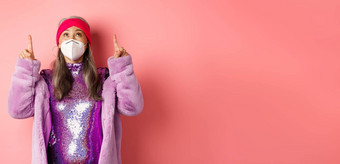 冠状病毒购物概念时尚亚洲上了年纪的女人迪斯科衣服呼吸器检查促销提供指出粉红色的背景