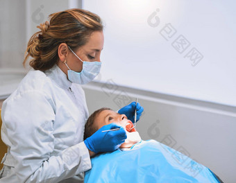 位年轻的男孩说谎牙医椅子检查牙医
