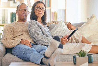 成熟的夫妇平板电脑放松肖像沙发爱支持浪漫成键生活房间首页男人。微笑快乐女人浪漫的质量时间沙发上科技设备