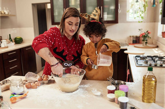 使测量正确快乐的年轻的女人儿子烘焙饼干厨房圣诞节时间首页