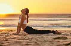 瑜伽Cobra拉伸女人海滩健身健康健康日落Zen脉轮女瑜珈练习普拉提冥想培训伸展运动锻炼在户外海滨