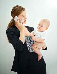 妍工作母亲覆盖成功的年轻的女商人携带可爱的婴儿男孩会说话的电话