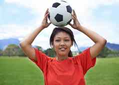 赢得年轻的女足球球员持有足球球