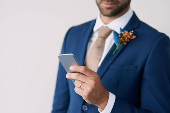 婚礼誓言移动形式裁剪工作室拍摄时尚的新郎移动电话灰色的背景