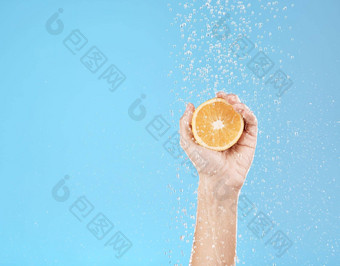 手橙色水自然护肤品健康健康有机水果蓝色的工作室背景美新鲜的食物多汁的维生素皮肤护理治疗皮肤病学