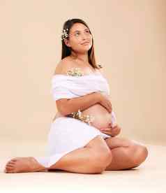 怀孕怀孕了女人花坐着美发光孤立的工作室背景皮肤发光自然化妆品自然快乐妈妈。产前化妆品护理模型