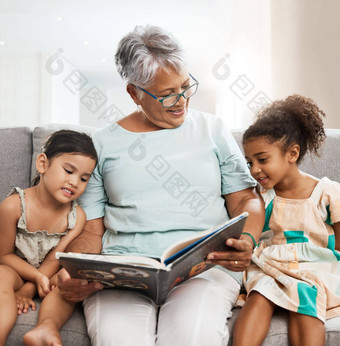 家庭祖母孩子们书阅<strong>读</strong>沙发成键放松质量时间爱教育上了年纪的女人女孩学习<strong>读故事</strong>仙女演讲文学
