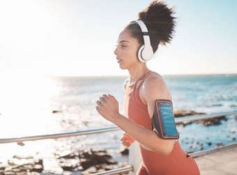 黑色的女人健身运行耳机手机手臂海滩角小镇运动非洲美国女跑步者海洋海岸运行有氧运动培训锻炼