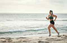 女人听音乐运行海滩早....有氧运动例程健康的生活方式加州健身锻炼海年轻的运动员耳机体育锻炼夏天模型
