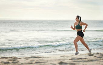 女人听音乐运行海滩早....有氧运动例程健康的生活方式加州健身锻炼海年轻的运动员耳机体育锻炼夏天模型