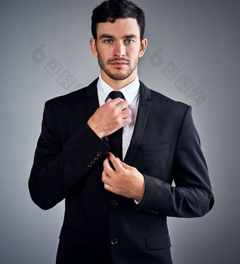 焦点<strong>征服企业</strong>世界工作室肖像英俊的年轻的商人穿着西装灰色背景