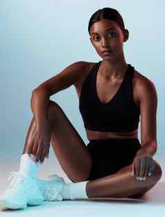 女人健身摆姿势蓝色的背景工作室健身房衣服健康目标健康心态体育目标肖像模型个人教练锻炼培训锻炼的想法