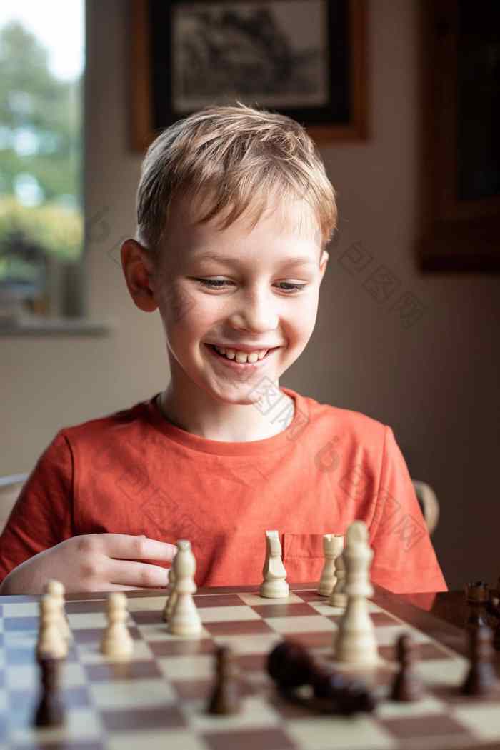 年轻的白色孩子玩游戏国际象棋大国际象棋董
