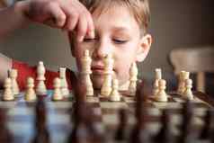 年轻的白色孩子玩游戏国际象棋大国际象棋董事会国际象棋董事会表格前面学校男孩思考移动