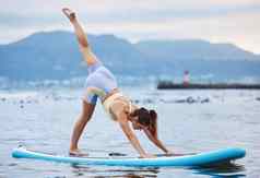 女人冲浪板水瑜伽海洋海放松锻炼培训锻炼核心平衡健康健康Zen平静和平人桨董事会自然健身身体普拉提