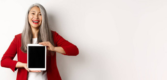 业务快乐的亚洲女商人红色的夹克显示数字平板电脑屏幕微笑介绍应用程序促销活动白色背景