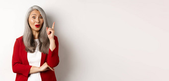 上了年纪的亚洲女人企业家红色的夹克的想法建议提高手指尤里卡手势站白色背景