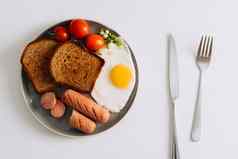 早餐板刀叉白色表格烤香肠小麦烤面包炸蛋樱桃西红柿板