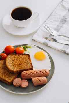 早餐板杯黑色的咖啡烤香肠小麦烤面包炸蛋樱桃西红柿板
