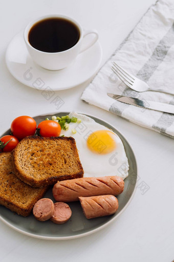 早餐板杯黑色的咖啡烤香肠小麦烤面包炸蛋樱桃西红柿板