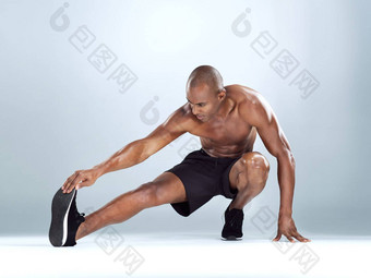 触摸<strong>脚趾</strong>工作室拍摄运动年轻的男人。<strong>伸展</strong>运动练习摆姿势灰色背景
